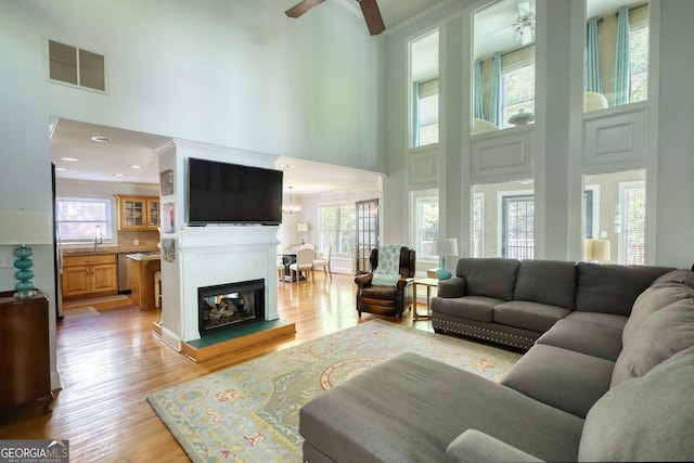 4157 Town Branch Ct SW, Covington, GA 30014 - living area featuring visible vents, a towering ceiling, ceiling fan, and light wood finished floors