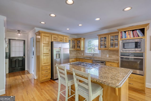 4157 Town Branch Ct SW, Covington, GA 30014 - kitchen featuring crown molding, appliances with stainless steel finishes, a sink, and light wood-type flooring