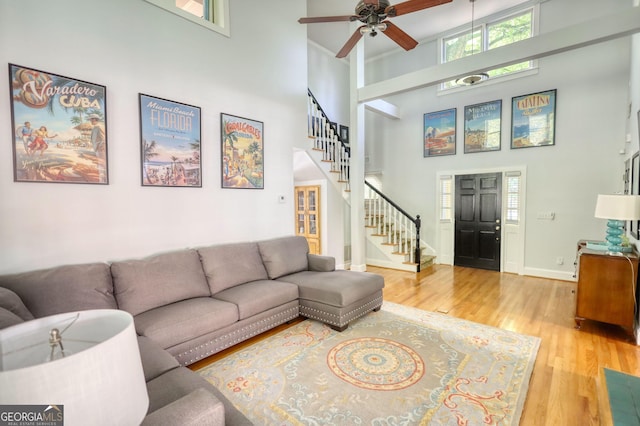 4157 Town Branch Ct SW, Covington, GA 30014 - living area featuring a ceiling fan, wood finished floors, baseboards, a high ceiling, and stairs