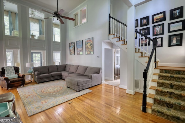 4157 Town Branch Ct SW, Covington, GA 30014 - living area featuring a high ceiling, stairs, wood finished floors, and visible vents