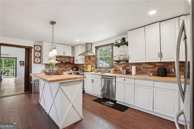 1060 Stephen St, Greensboro, GA 30642 - kitchen featuring appliances with stainless steel finishes, wall chimney range hood, butcher block countertops, white cabinets, and recessed lighting