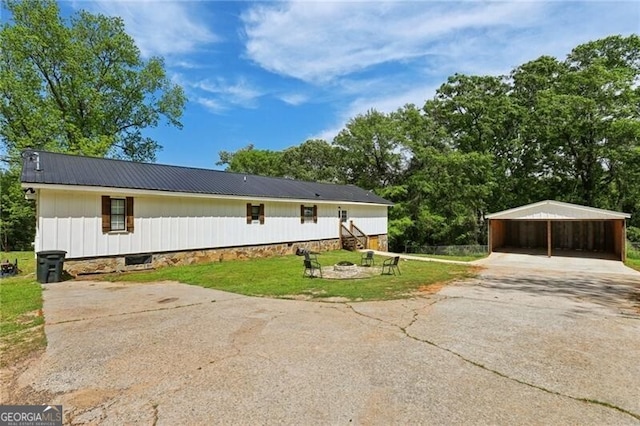 1060 Stephen St, Greensboro, GA 30642 - view of front facade featuring asphalt driveway, a carport, a front yard, a metal roof, and a fire pit