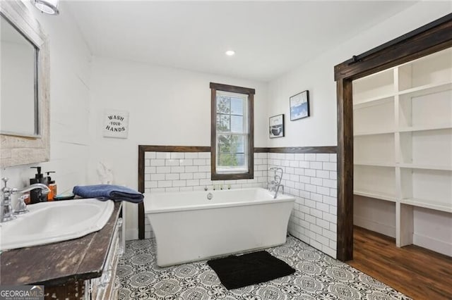 1060 Stephen St, Greensboro, GA 30642 - bathroom with vanity, tile walls, a soaking tub, wainscoting, and recessed lighting
