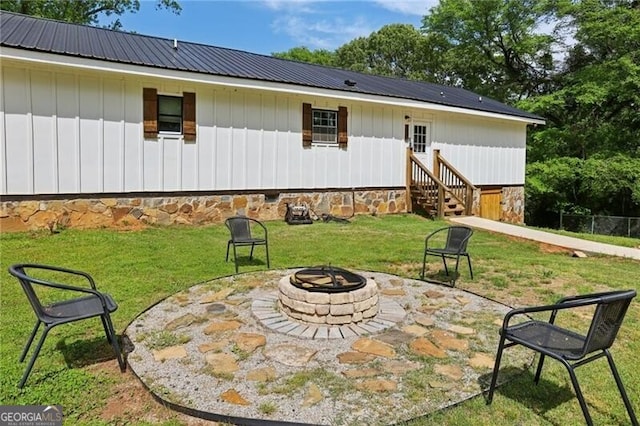 1060 Stephen St, Greensboro, GA 30642 - back of house with a fire pit, a metal roof, a lawn, a patio area, and board and batten siding