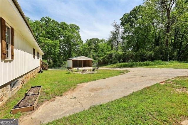 1060 Stephen St, Greensboro, GA 30642 - view of grassy yard with an outbuilding, view of wooded area, and a garden
