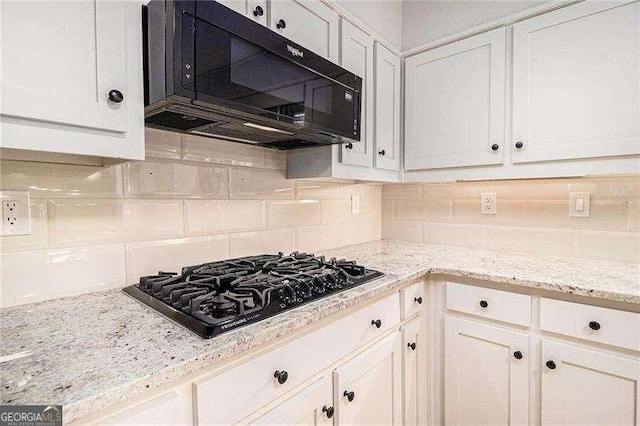 kitchen featuring white cabinetry, backsplash, black appliances, and light stone countertops