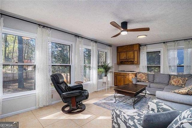 living room featuring a ceiling fan, a textured ceiling, and a healthy amount of sunlight