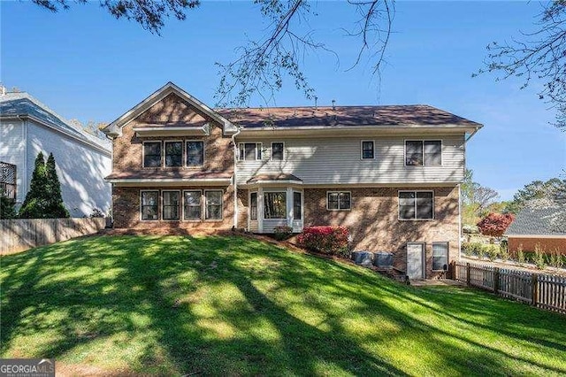 back of property featuring a fenced backyard and a yard
