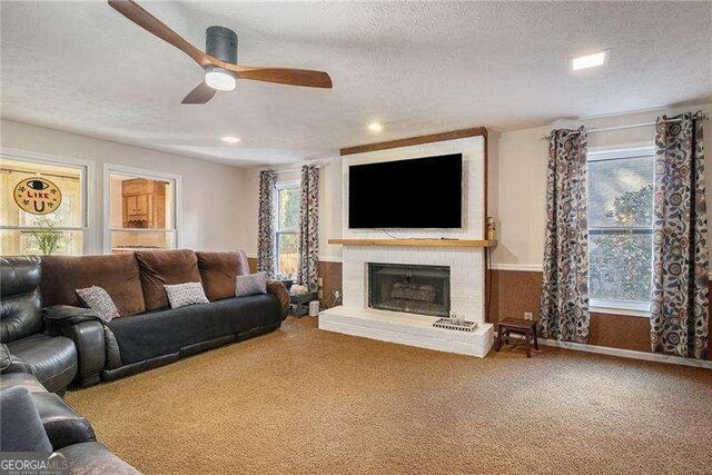 5000 Bainbridge Ct SW, Lilburn, GA 30047 - carpeted living room with a textured ceiling, a ceiling fan, a brick fireplace, and recessed lighting