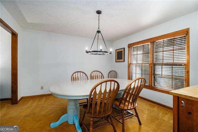 dining area with baseboards, carpet flooring, a textured ceiling, and a chandelier