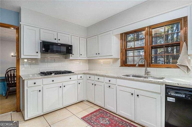 kitchen featuring a sink, white cabinetry, black appliances, and tasteful backsplash