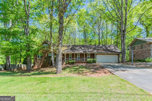 view of front of home with fence, driveway, a porch, a front yard, and a garage