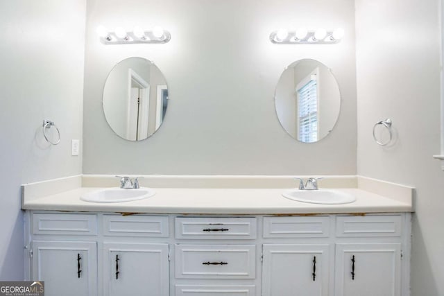 full bathroom with a sink and double vanity