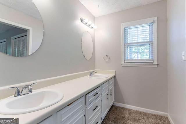 full bath featuring baseboards, a sink, and double vanity