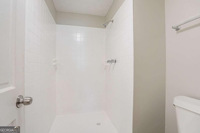 full bath featuring toilet and tiled shower