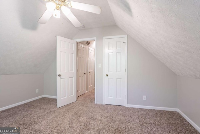 bonus room featuring lofted ceiling, carpet, baseboards, and a textured ceiling