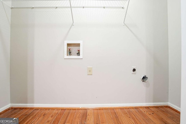 washroom with hookup for a washing machine, electric dryer hookup, light wood-style flooring, baseboards, and laundry area