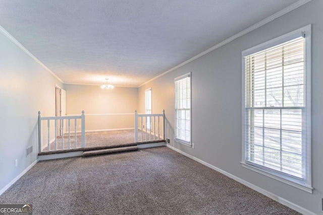 carpeted empty room featuring visible vents, baseboards, ornamental molding, and an inviting chandelier