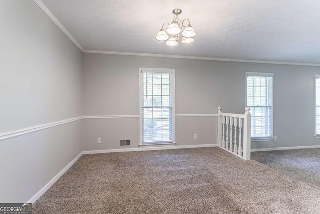 spare room with visible vents, carpet flooring, a healthy amount of sunlight, and an inviting chandelier