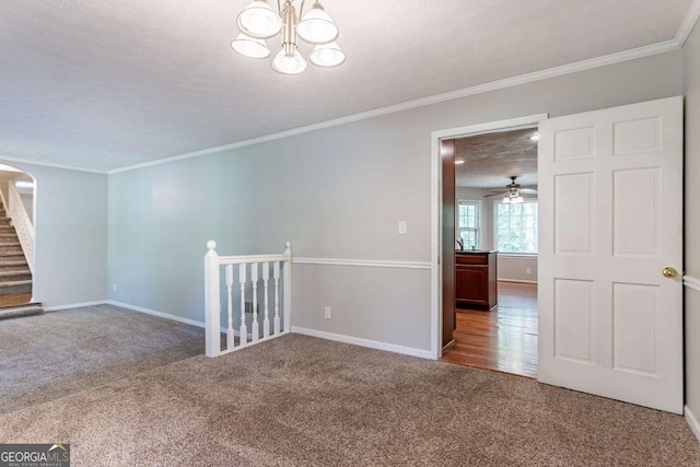empty room featuring carpet floors, ornamental molding, and an inviting chandelier