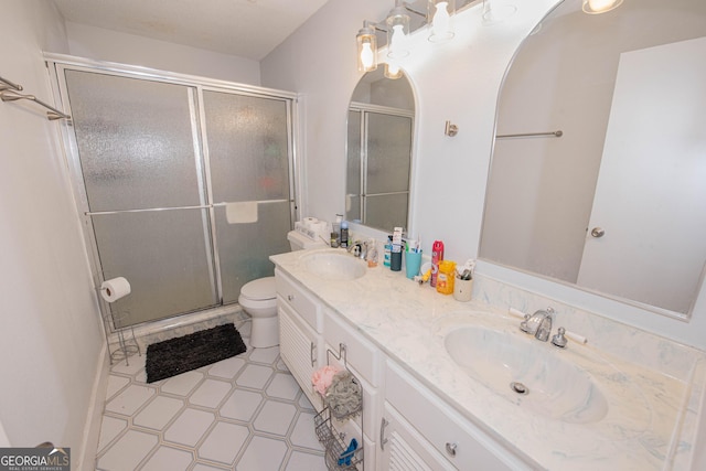 full bath with double vanity, a shower stall, toilet, and a sink