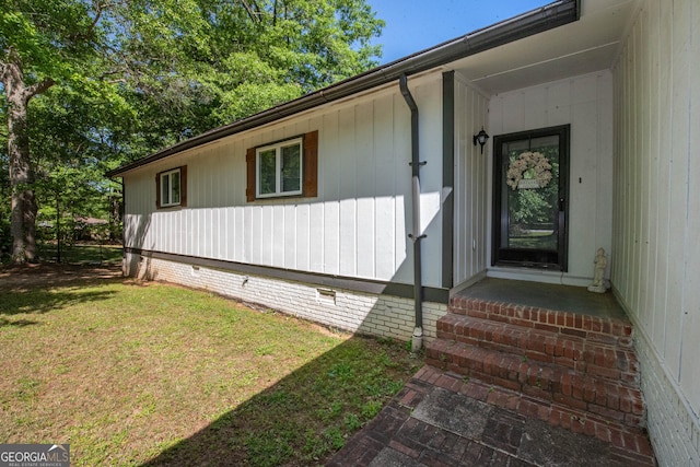 entrance to property with crawl space and a yard