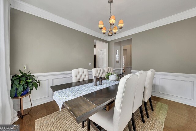213 Roseman Way, Woodstock, GA 30188 - dining room featuring a chandelier, ornamental molding, a wainscoted wall, wood finished floors, and a decorative wall