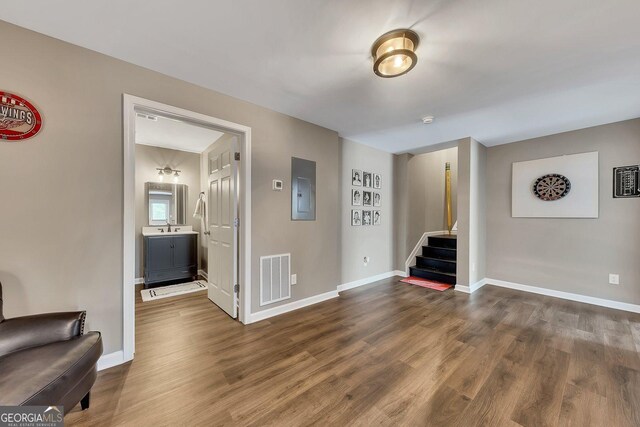 213 Roseman Way, Woodstock, GA 30188 - unfurnished living room with stairway, dark wood-style flooring, baseboards, electric panel, and a sink