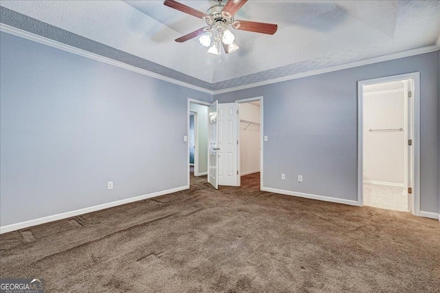 unfurnished bedroom with ornamental molding, baseboards, carpet flooring, and a raised ceiling