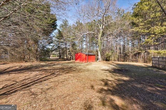 view of yard featuring an outbuilding and fence