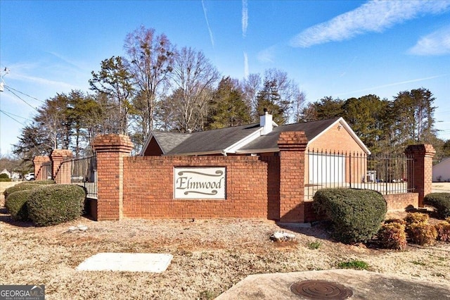 community / neighborhood sign featuring fence