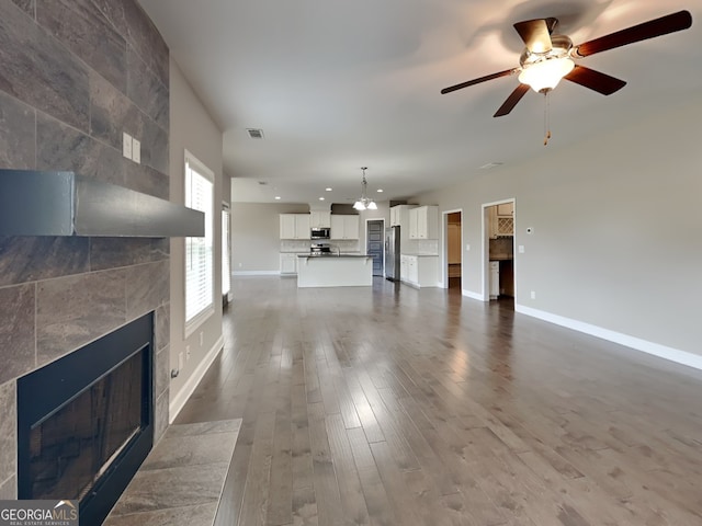 1820 Cobblefield Cir, Dacula, GA 30019 - unfurnished living room featuring a tiled fireplace, recessed lighting, baseboards, a ceiling fan, and dark wood-style flooring