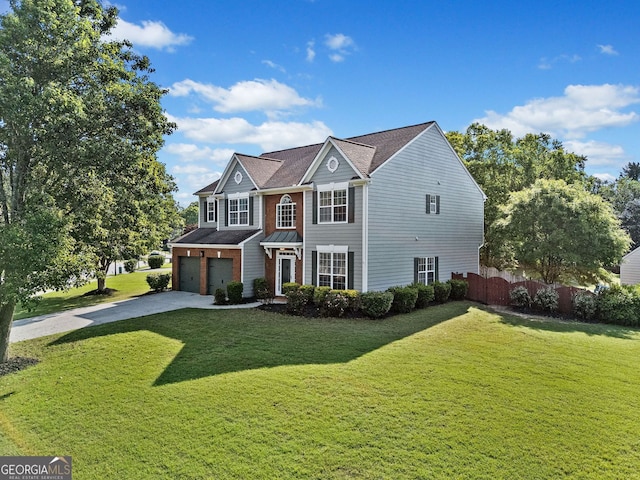 traditional home with a garage, fence, concrete driveway, and a front lawn
