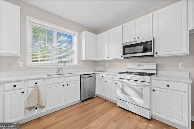 kitchen featuring a sink, light countertops, stainless steel appliances, and light wood-style flooring