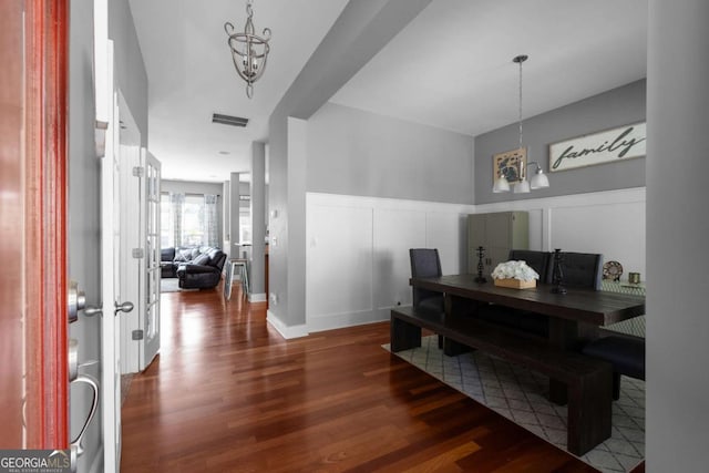 9988 Devonshire St, Douglasville, GA 30135 - dining room featuring visible vents, wood finished floors, a wainscoted wall, a notable chandelier, and a decorative wall