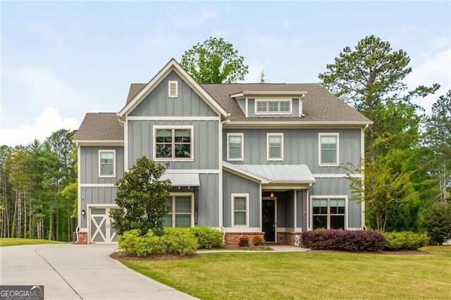 craftsman-style house featuring a front lawn, board and batten siding, driveway, roof with shingles, and a garage