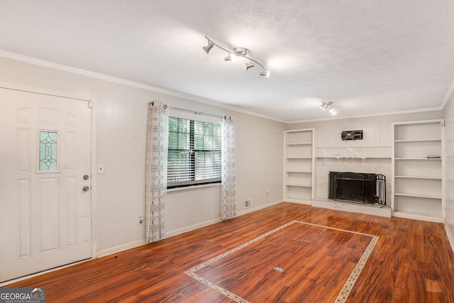 unfurnished living room featuring crown molding, a fireplace, baseboards, wood finished floors, and visible vents