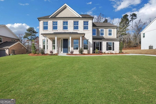 view of front of home with a porch, brick siding, and a front yard