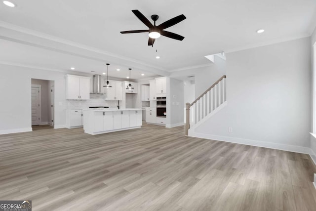 unfurnished living room with light wood finished floors, baseboards, recessed lighting, a ceiling fan, and stairs