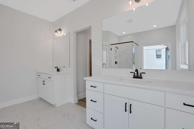 full bath featuring two vanities, baseboards, a marble finish shower, and a sink