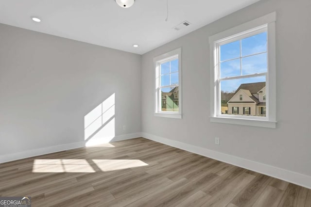 spare room with visible vents, light wood-style flooring, baseboards, and recessed lighting