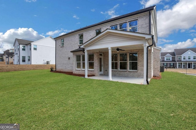 back of property featuring a patio area, brick siding, a ceiling fan, and a lawn