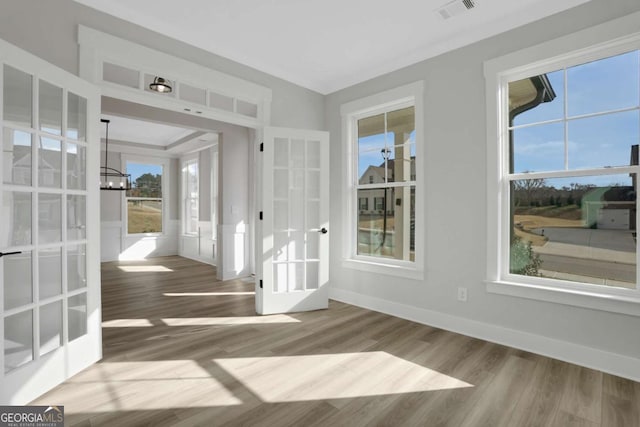 entryway with plenty of natural light, wood finished floors, visible vents, and a notable chandelier