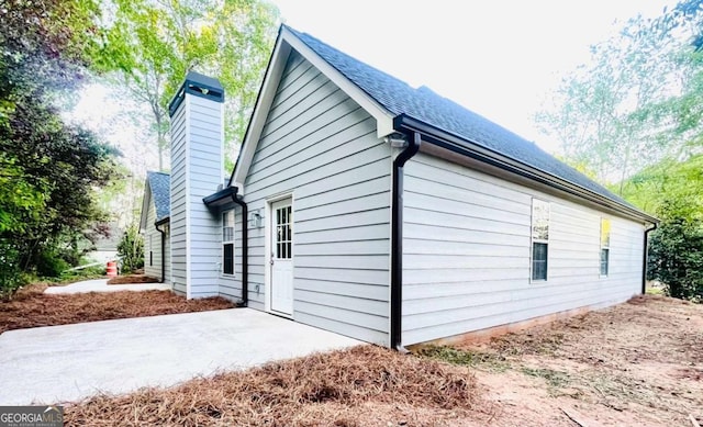 7675 Lanier View Rdg, Cumming, GA 30041 - view of home's exterior featuring a chimney and a patio