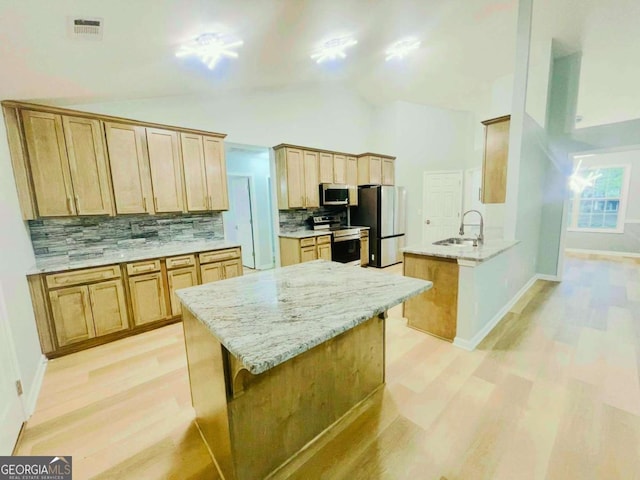 7675 Lanier View Rdg, Cumming, GA 30041 - kitchen featuring stainless steel appliances, light wood-style floors, decorative backsplash, a peninsula, and a sink