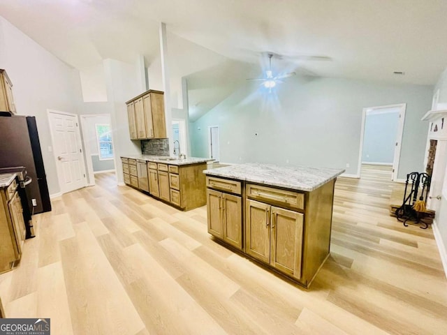 7675 Lanier View Rdg, Cumming, GA 30041 - kitchen with ceiling fan, light wood-style flooring, appliances with stainless steel finishes, brown cabinets, and high vaulted ceiling