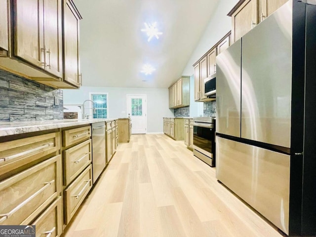 7675 Lanier View Rdg, Cumming, GA 30041 - kitchen featuring stainless steel appliances, light wood finished floors, tasteful backsplash, lofted ceiling, and light stone counters