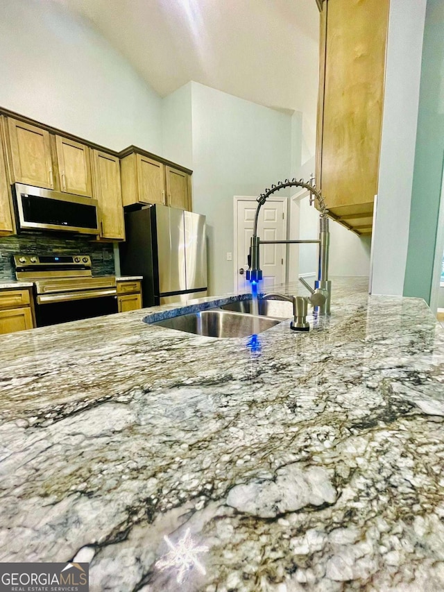 7675 Lanier View Rdg, Cumming, GA 30041 - kitchen featuring stainless steel appliances, light stone countertops, backsplash, and lofted ceiling