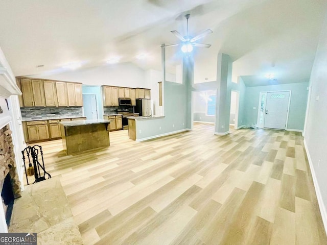 7675 Lanier View Rdg, Cumming, GA 30041 - kitchen featuring stainless steel appliances, open floor plan, a fireplace, ceiling fan, and backsplash