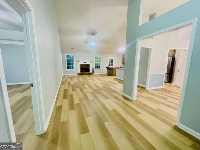 7675 Lanier View Rdg, Cumming, GA 30041 - unfurnished living room with light wood-style flooring, baseboards, ceiling fan, and a fireplace with raised hearth